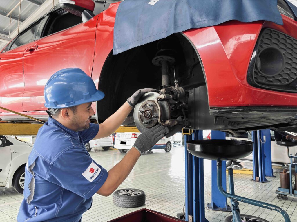 Teknisi Suzuki Memeriksa Sistem Rem Mobil di Bengkel Resmi. Suzuki mengingatkan pemudik memastikan sistem rem mobil optimal demi keselamatan perjalanan jauh. /Suzuki